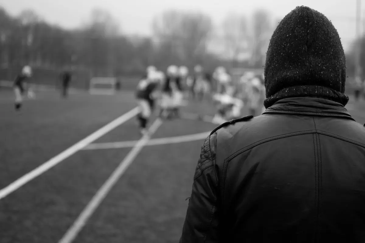 Someone watching a game from the touchline